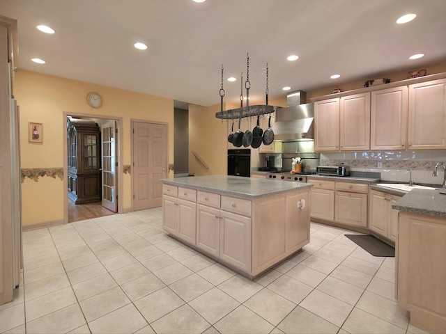 10160 Lancaster Dr, Mokena, IL 60448 - kitchen with wall chimney range hood, oven, a center island, and light tile patterned flooring