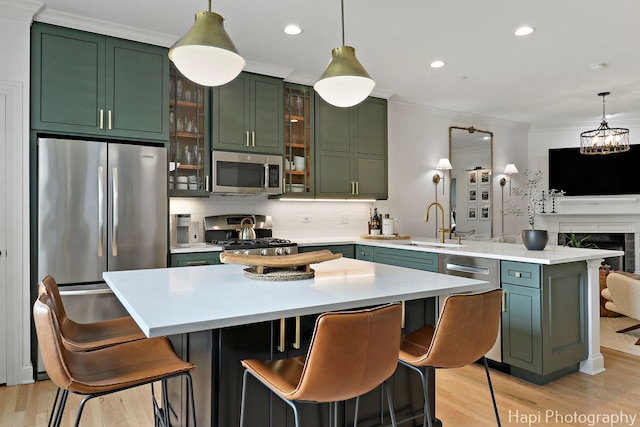 623 Broadway St, Libertyville, IL 60048 - kitchen featuring green cabinetry, appliances with stainless steel finishes, light countertops, light wood-style flooring, and a peninsula