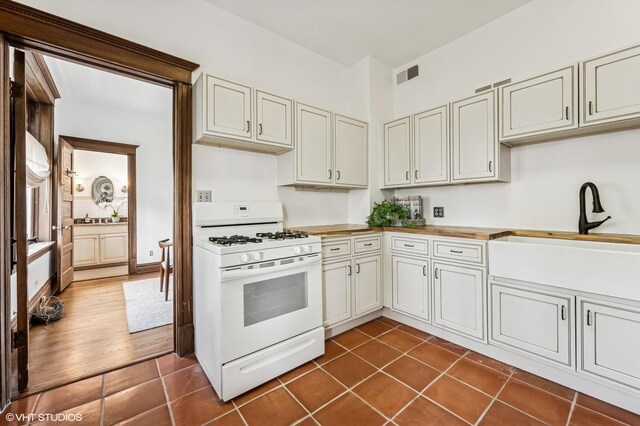 2137 W Cortez St Unit 2, Chicago, IL 60622 - kitchen with white gas stove, a sink, dark tile patterned flooring, and wooden counters