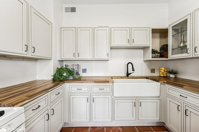 2137 W Cortez St Unit 2, Chicago, IL 60622 - kitchen featuring wood counters, a sink, and glass insert cabinets