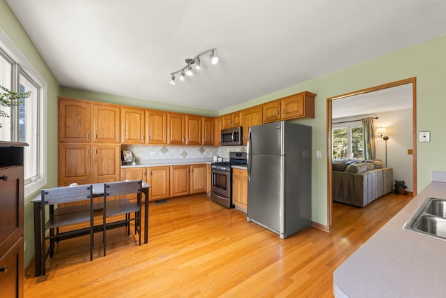 1500 E Lowden Ave, Wheaton, IL 60189 - kitchen featuring appliances with stainless steel finishes, light wood finished floors, decorative backsplash, light countertops, and brown cabinetry