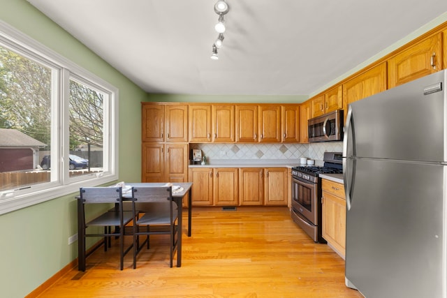 1500 E Lowden Ave, Wheaton, IL 60189 - kitchen featuring stainless steel appliances, tasteful backsplash, light wood-style flooring, light countertops, and brown cabinets
