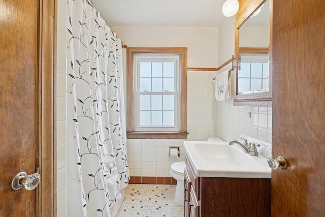 full bath with tile walls, toilet, curtained shower, and vanity
