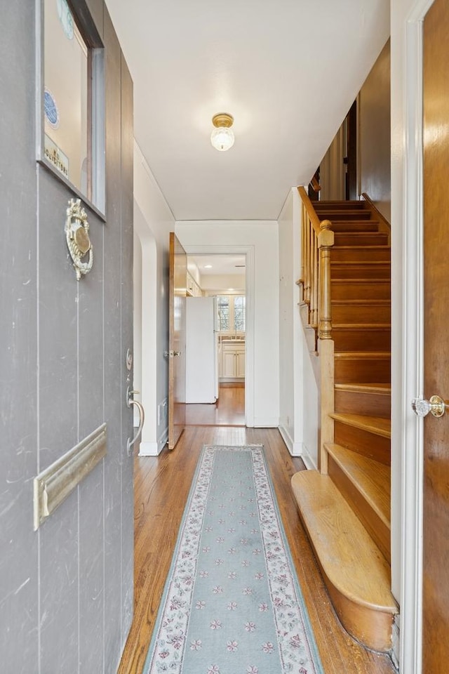 entrance foyer featuring stairway, baseboards, and wood finished floors