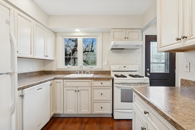 kitchen with a sink, white appliances, under cabinet range hood, and a wealth of natural light