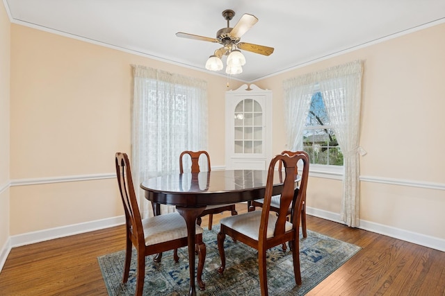dining space featuring baseboards, ornamental molding, ceiling fan, and wood finished floors