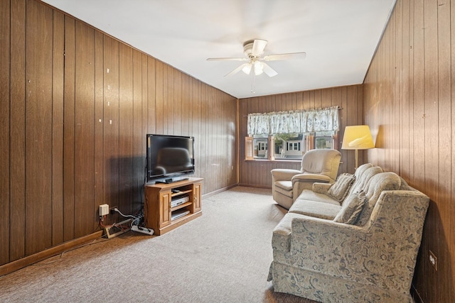 carpeted living area featuring a ceiling fan and wooden walls