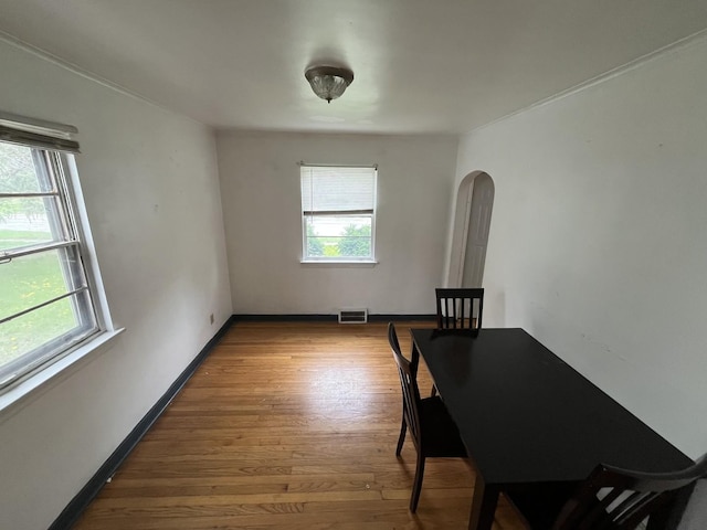 156 W 141st St, Riverdale, IL 60827 - dining room featuring arched walkways, baseboards, visible vents, and wood finished floors