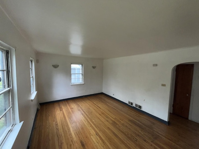 156 W 141st St, Riverdale, IL 60827 - spare room featuring arched walkways, baseboards, visible vents, and wood finished floors