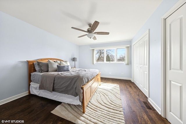 bedroom featuring a ceiling fan, visible vents, baseboards, a closet, and dark wood-type flooring