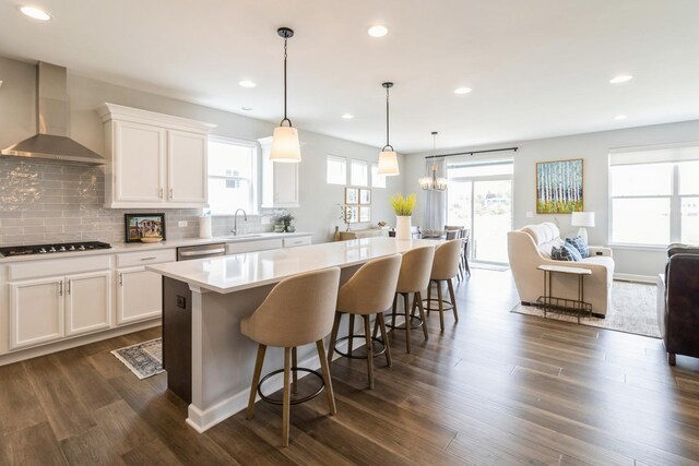 302 Links Dr, Addison, IL 60101 - kitchen with wall chimney range hood, a center island, decorative backsplash, a sink, and white cabinetry