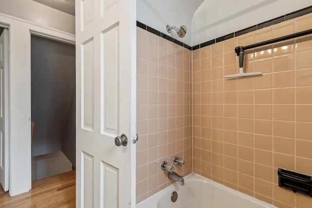 full bath with wood finished floors and washtub / shower combination