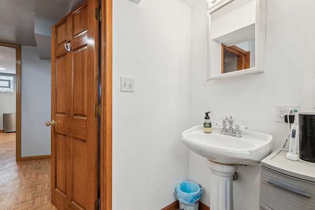 bathroom with a sink and baseboards