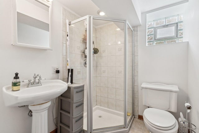 bathroom featuring a stall shower, toilet, and tile patterned floors