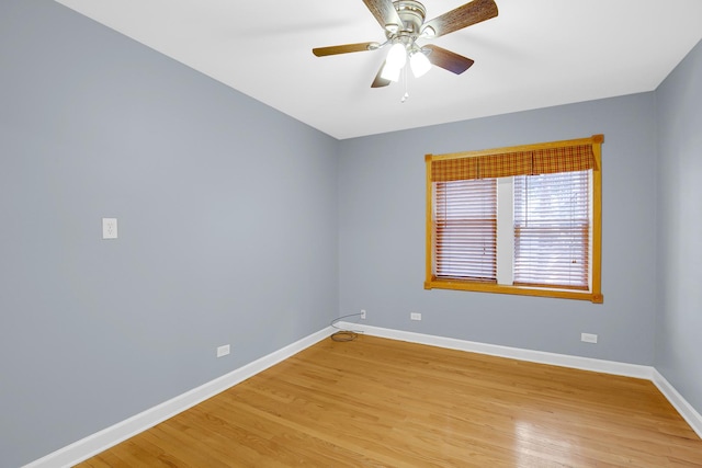 empty room featuring baseboards, light wood finished floors, and a ceiling fan