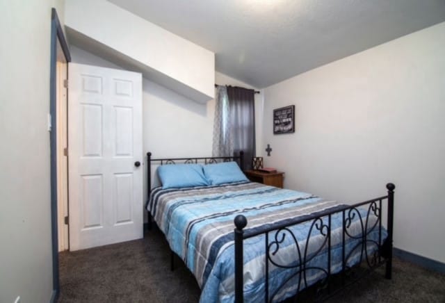 carpeted bedroom with lofted ceiling