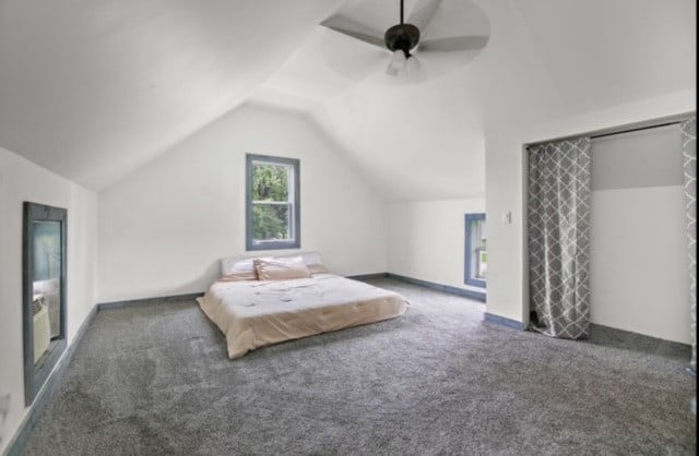 carpeted bedroom featuring ceiling fan and vaulted ceiling