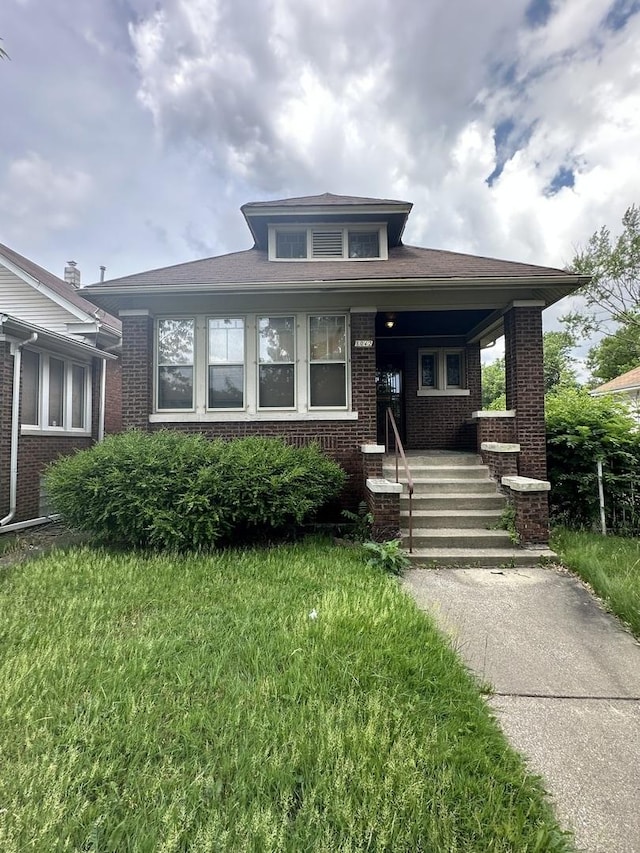 8042 S Bennett Ave, Chicago, IL 60617 - bungalow featuring brick siding, a porch, and a front yard