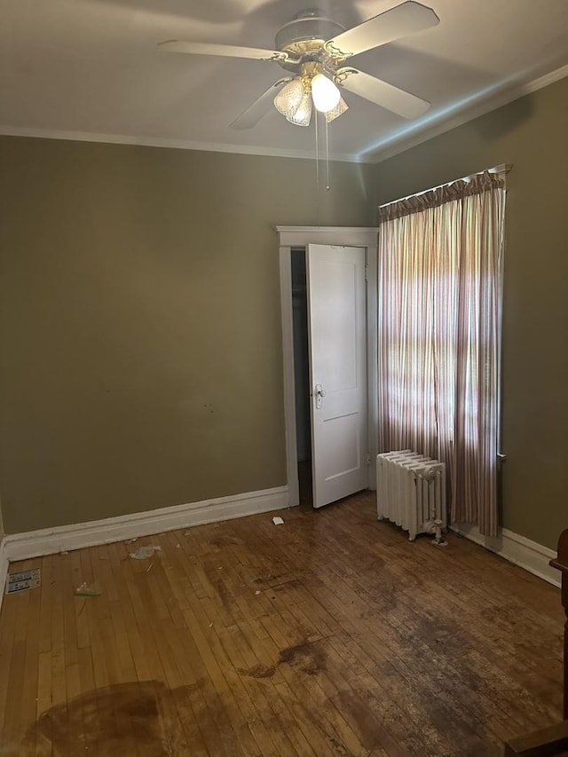 8042 S Bennett Ave, Chicago, IL 60617 - spare room featuring radiator heating unit, a ceiling fan, wood-type flooring, and crown molding