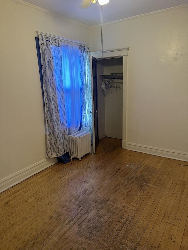 8042 S Bennett Ave, Chicago, IL 60617 - unfurnished bedroom featuring radiator, hardwood / wood-style floors, crown molding, a closet, and a ceiling fan