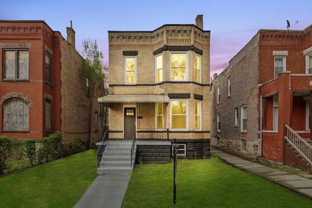 italianate-style house featuring brick siding, a front yard, and a porch
