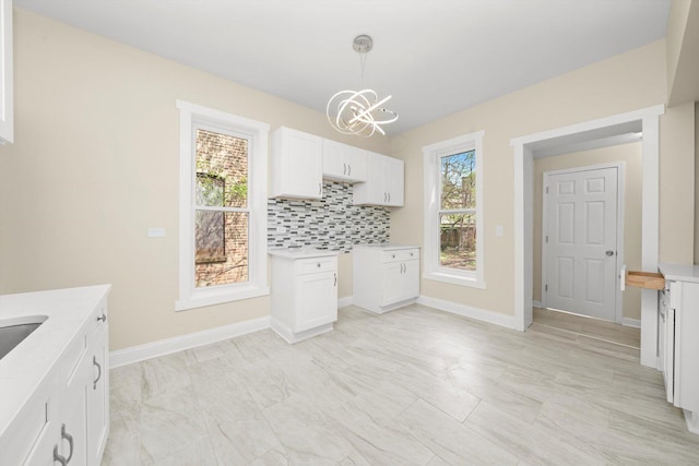 unfurnished dining area with baseboards and an inviting chandelier
