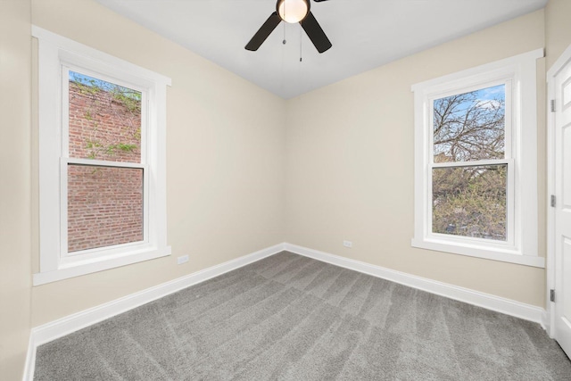 carpeted empty room with ceiling fan, a healthy amount of sunlight, and baseboards