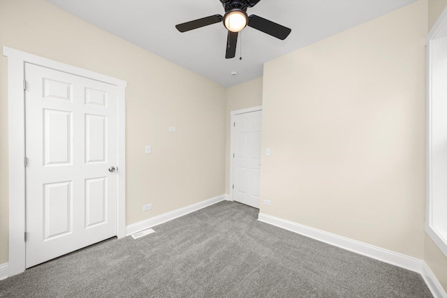 unfurnished bedroom featuring carpet floors, a ceiling fan, baseboards, and visible vents