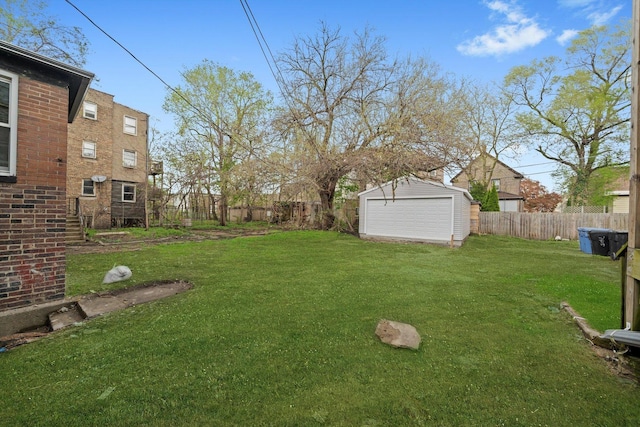 view of yard featuring a fenced backyard, an outbuilding, a storage shed, and a detached garage