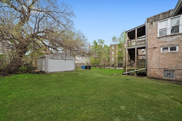 view of yard with a detached garage, fence, and an outdoor structure