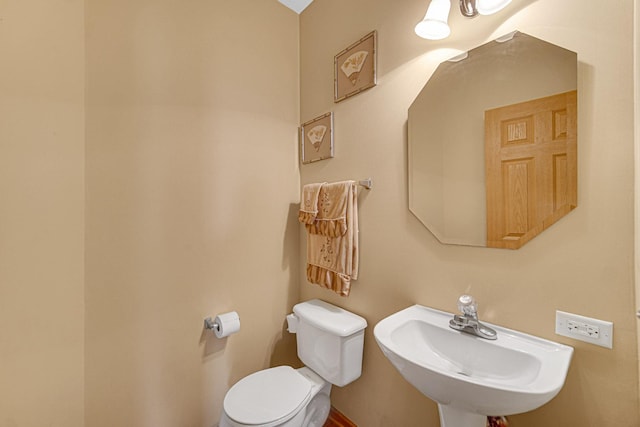 half bathroom with toilet and a sink
