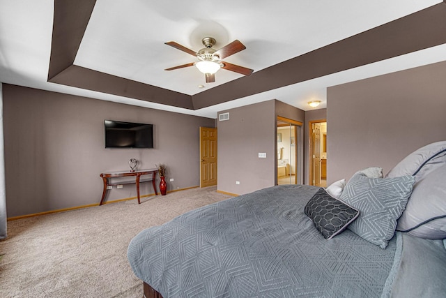 bedroom featuring carpet, visible vents, a tray ceiling, connected bathroom, and baseboards