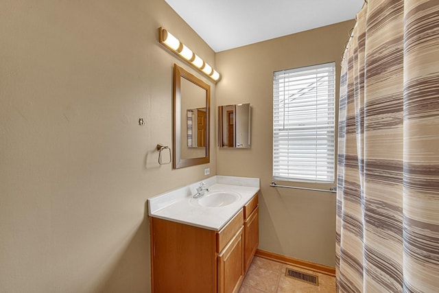 bathroom with tile patterned floors, visible vents, vanity, and a healthy amount of sunlight