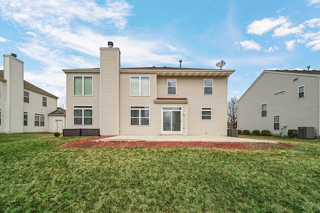 back of house featuring central AC, a chimney, a patio, and a lawn