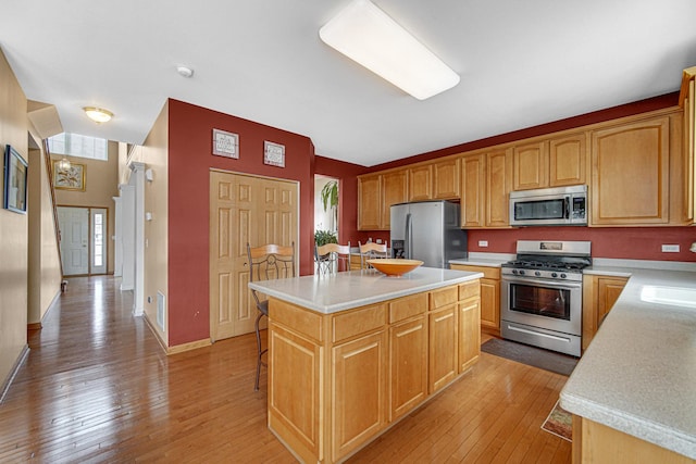 kitchen featuring a center island, light countertops, light wood-type flooring, and appliances with stainless steel finishes
