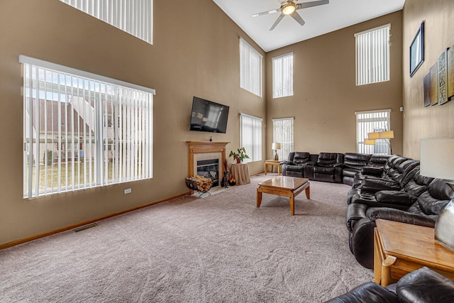 carpeted living area with visible vents, baseboards, a ceiling fan, and high vaulted ceiling