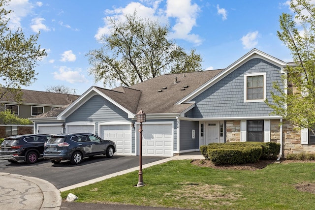 314 Wildberry Ct Unit A1, Schaumburg, IL 60193 - view of front of home with an attached garage, asphalt driveway, a front yard, stone siding, and roof with shingles