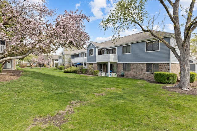 314 Wildberry Ct Unit A1, Schaumburg, IL 60193 - rear view of property with brick siding, a lawn, and a balcony