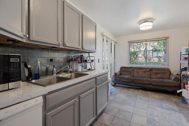 314 Wildberry Ct Unit A1, Schaumburg, IL 60193 - kitchen with white dishwasher, gray cabinetry, a sink, decorative backsplash, and light tile patterned floors