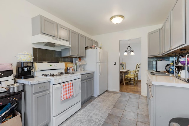 314 Wildberry Ct Unit A1, Schaumburg, IL 60193 - kitchen with white appliances, under cabinet range hood, gray cabinets, backsplash, and a chandelier