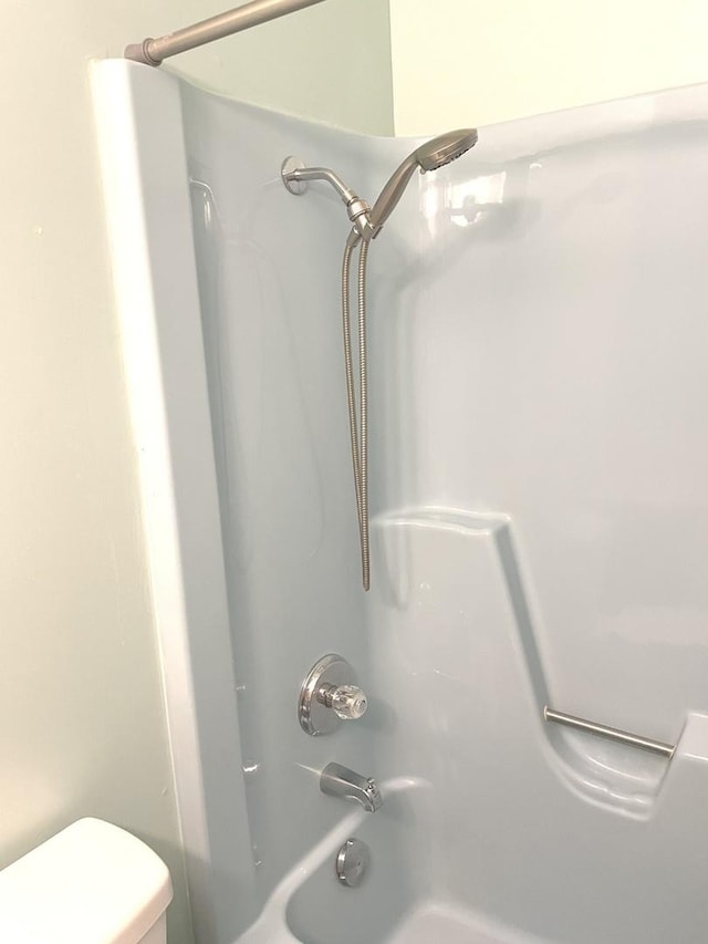 bathroom featuring toilet and  shower combination