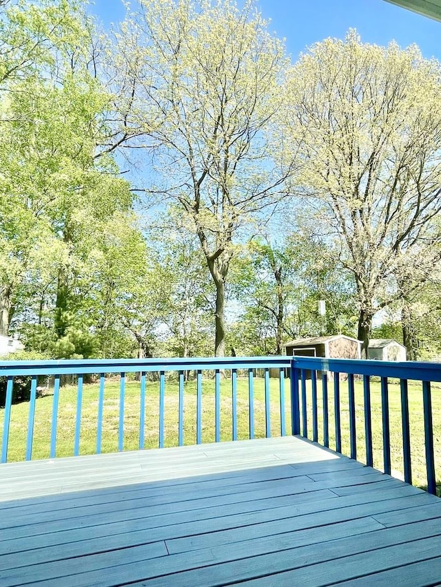 deck featuring an outdoor structure and a yard