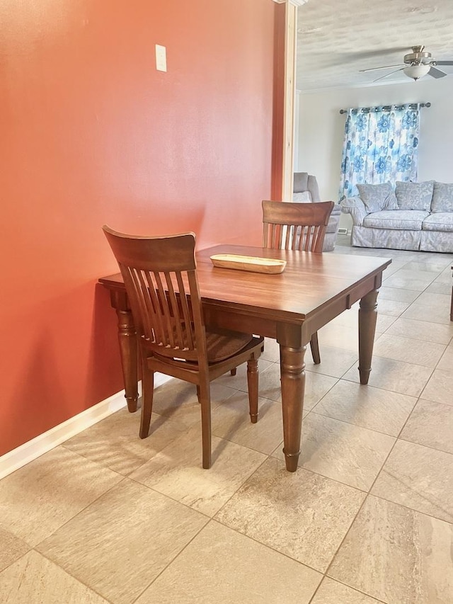 dining area with a ceiling fan, baseboards, and light tile patterned floors