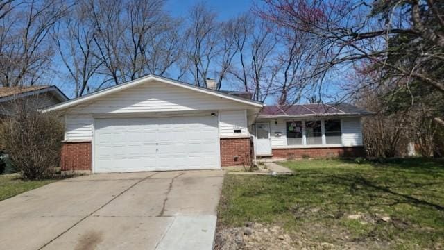 view of front facade featuring an attached garage, concrete driveway, a front lawn, and brick siding