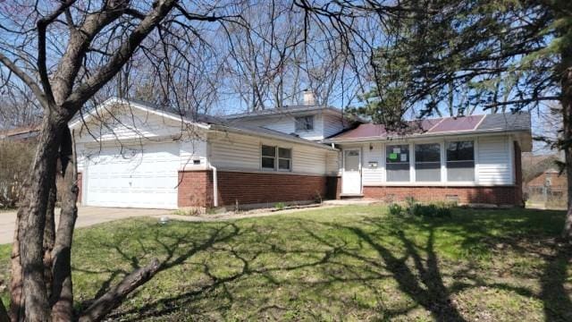 split level home with brick siding, a garage, a front lawn, and concrete driveway