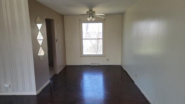 interior space featuring baseboards, ceiling fan, visible vents, and wood finished floors