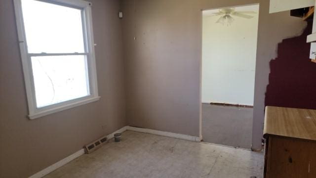 unfurnished room with ceiling fan, visible vents, and baseboards