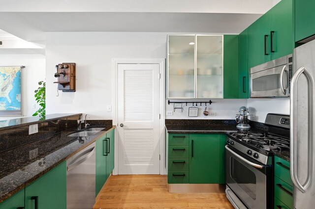 1610 N Whipple St Unit 2, Chicago, IL 60647 - kitchen featuring stainless steel appliances, a sink, light wood-type flooring, dark stone countertops, and green cabinets