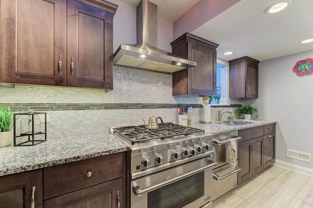 221 8th St, Downers Grove, IL 60515 - kitchen featuring wall chimney exhaust hood, high end stove, a sink, baseboards, and backsplash