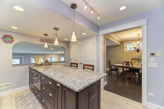 221 8th St, Downers Grove, IL 60515 - kitchen with arched walkways, dark brown cabinets, baseboards, light stone counters, and recessed lighting